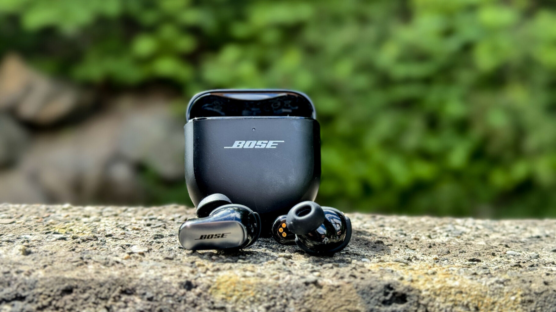 Bose QuietComfort Ultra Earbuds - spread a black earbuds in a case