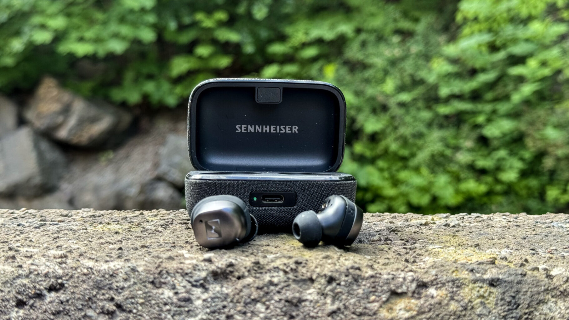 a black earbuds and a box on a rock Sennheiser Momentum True Wireless 4 - spread 2
